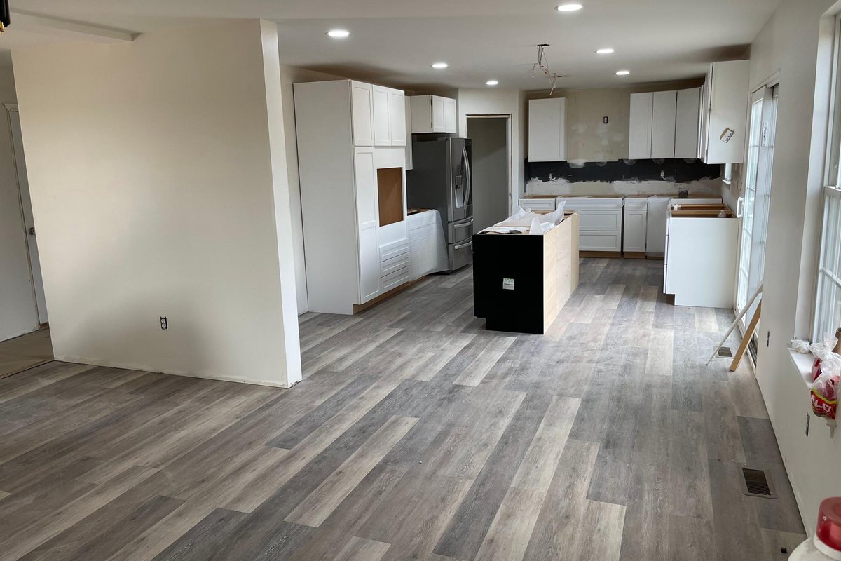 Open-plan kitchen with island and new plank flooring by MDM Painting & Remodeling, Reading