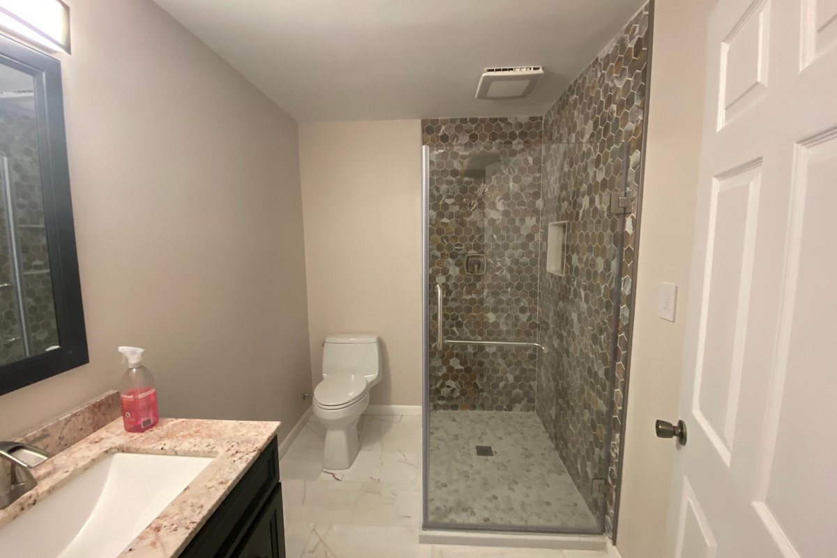 Walk-in shower tiled to the ceiling beside a fitted vanity by MDM Painting & Remodeling, Reading